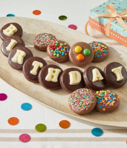 Chocolate-covered Oreo cookies spelling 'Happy Birthday' with sprinkles in a gift box
