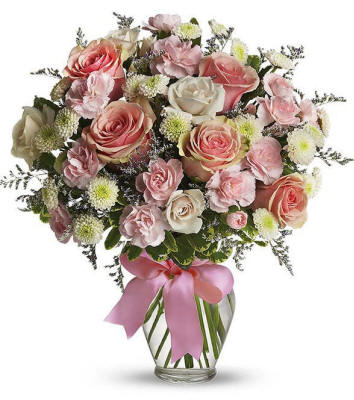 Soft pastel flowers in a glass vase with roses and carnations