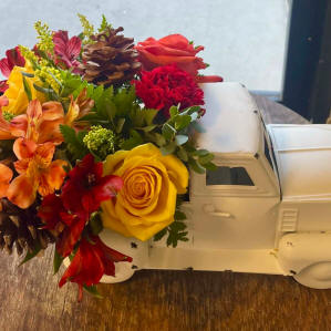 A truck filled with mixed roses, lilies and flowers