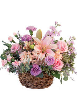 A basket filled with a variety of pink roses and flowers