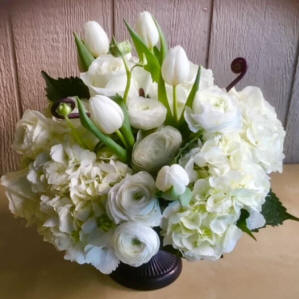 A vase filled with a mixture of white flowers