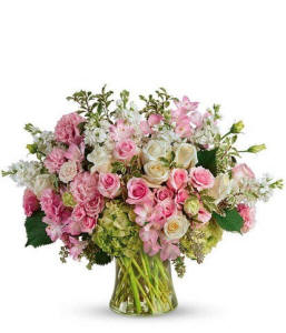 A glass vase filled with a variety of pink and white flowers and roses