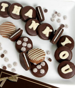chocolate-covered Oreo cookies spelling 'Thank You' on a white plate